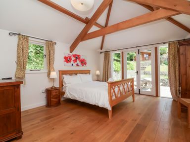 A bedroom with a bed and nightstand at Old Maids Cottage in Woolacombe