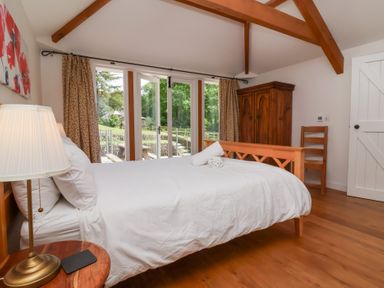 A bedroom with a bed and wardrobe at Old Maids Cottage in Woolacombe