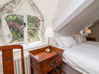 A bedroom with a bed and nightstand at Old Maids Cottage in Woolacombe