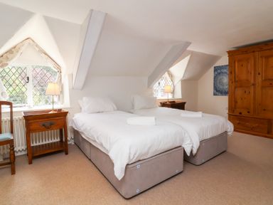 A bedroom with two beds and a nightstand at Old Maids Cottage in Woolacombe