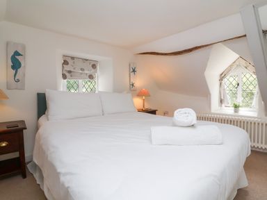 A bedroom with a large bed and nightstand at Old Maids Cottage in Woolacombe