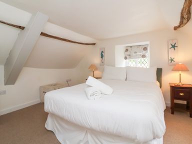 A bedroom with a bed and a bedside table at Old Maids Cottage in Woolacombe