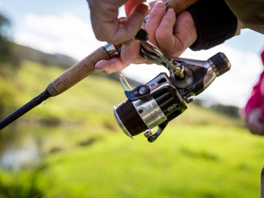 A close-up of a fishing rod and reel with fishing line outdoors at Bwthyn Bach Brefi