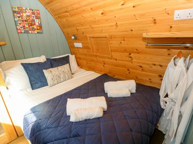A bedroom with a bed and decorative wall art at Bwthyn Bach Brefi in Llanddewi-Brefi