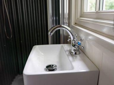 A white rectangular sink with a chrome faucet near a window in a bathroom at Onnen in Oakford near Aberaeron