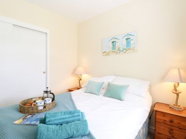 A bedroom with a double bed bedside tables and lamps at The Cranny in Mundesley