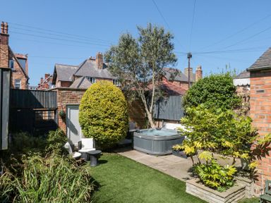 A garden with chairs table hot tub and various plants at Royal Victoria House in Scarborough