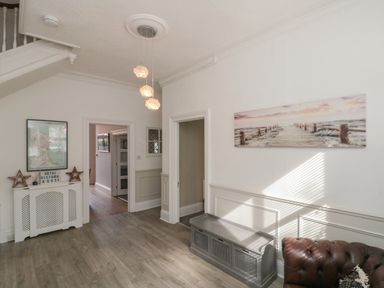 A hallway with a console table and wall art at Royal Victoria House in Scarborough