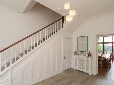 A hallway with a staircase and a dining area at Royal Victoria House in Scarborough