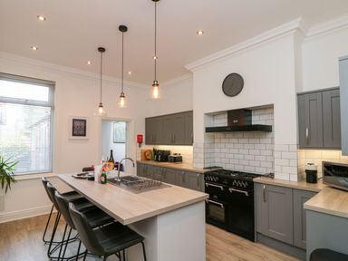 A kitchen with an island and stools at Royal Victoria House in Scarborough