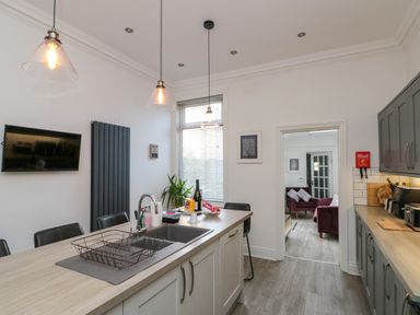 A kitchen with a sink and seating area at Royal Victoria House in Scarborough