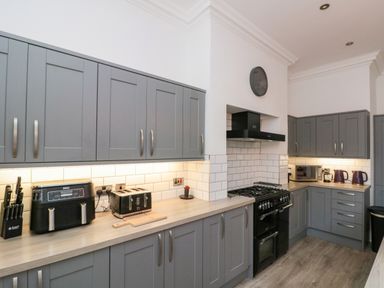 A kitchen with cabinets and appliances at Royal Victoria House in Scarborough