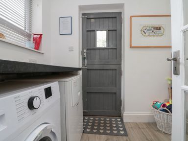A laundry room with a washing machine and door at Royal Victoria House Scarborough