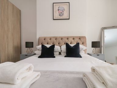 A bedroom with a bed and cushions at Royal Victoria House in Scarborough