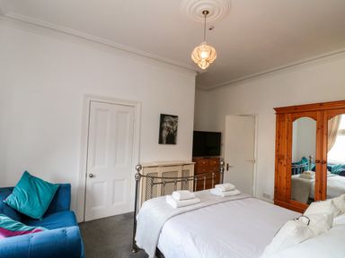 A bedroom with a bed and sofa at Royal Victoria House Scarborough