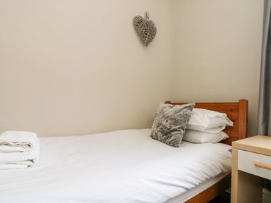 A bedroom with a bed and towels at Royal Victoria House in Scarborough