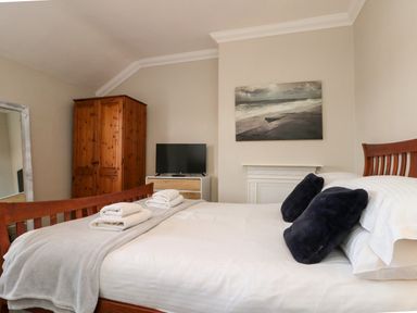 A bedroom with a bed and television at Royal Victoria House in Scarborough