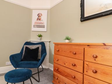A sitting room with a chair and a dresser at Royal Victoria House Scarborough