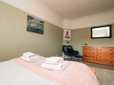 A bedroom with a bed, towels, chair, and dresser at Royal Victoria House in Scarborough