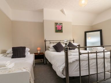 A bedroom with two beds and a mirror at Royal Victoria House Scarborough