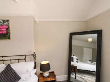 A bedroom with a bed and mirror at Royal Victoria House Scarborough