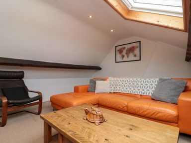 A snug with an orange sofa and wooden coffee table at Royal Victoria House in Scarborough