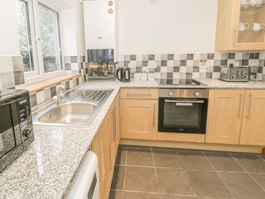 A kitchen with a sink microwave oven toaster and kettle at Crud yr Awel in Braichmelyn near Bethesda