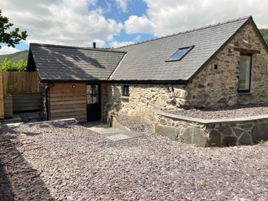 Stone cottage with slate roof and gravel yard at The Shippon in Llanrwst