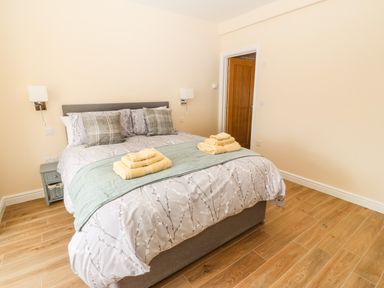 A bedroom with a double bed with pillows and folded towels on the bed at Trewen Botwnnog near Sarn Meyllteyrn