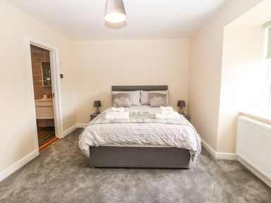 A bedroom with a double bed two bedside tables with lamps and an en suite bathroom at Trewen in Botwnnog near Sarn Meyllteyrn