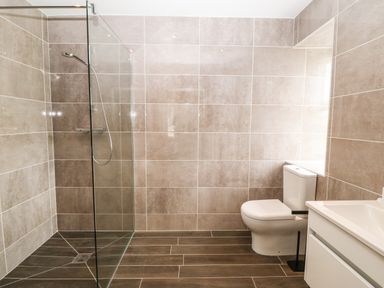A bathroom with a walk-in shower a toilet and a sink at Trewen in Botwnnog near Sarn Meyllteyrn