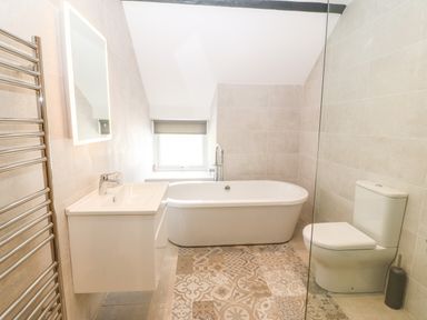 A bathroom with a bathtub sink toilet and towel rack at Trewen in Botwnnog near Sarn Meyllteyrn