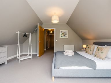 A bedroom with a bed towels pillows and bedside lamp at Golden Eagle Lodge in Aviemore