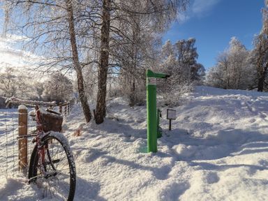 A bicycle and pump among snow and trees at Golden Eagle Lodge in Aviemore