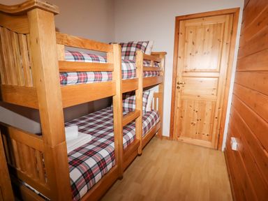A bedroom with wooden bunk beds and a wooden door at Watersview Lodge Rudyard near Leek