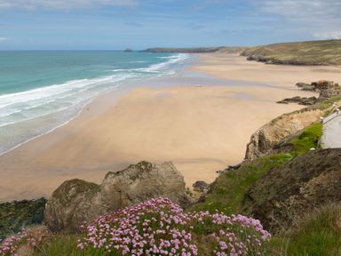 A beach with waves and cliffs overlooking sand and the ocean at Honeypot Lodge in Camelford