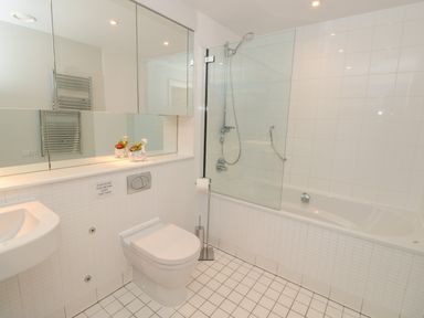 A bathroom with a toilet sink bathtub shower and large mirror at 42 Dart Marina in Dartmouth