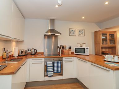 A kitchen with wooden countertops white cabinets stainless steel oven toaster microwave and wooden display cabinet at 42 Dart Marina in Dartmouth