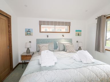 A bedroom with a double bed bedside tables lamps and a window at 1 Valley View in Lanreath