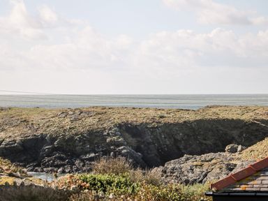 A coastal view with rocky cliffs and ocean in the background at Bay View in Trearddur Bay