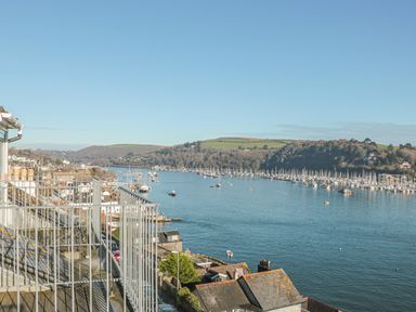 A river with boats and a railing in the foreground at Manor Studio in Dartmouth