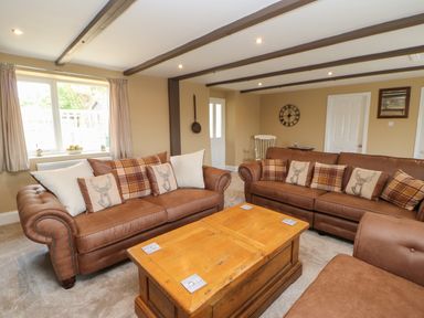A living room with brown sofas and a wooden coffee table at Crag View in West Woodburn