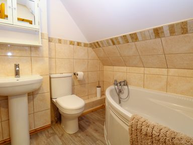 A bathroom with a pedestal sink toilet bathtub and wall tiles at Lillies Pad in Methwold near Feltwell
