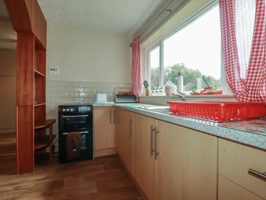 A kitchen with a stove and sink at Underlanes in Boscastle