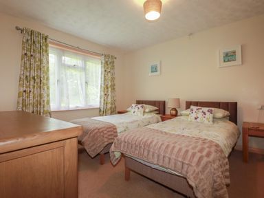 A bedroom with two beds and a window at Underlanes in Boscastle