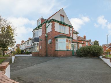 A residential street with red brick houses and driveways with parked cars and bushes at Hillcrest in Scarborough