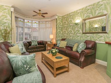 A living room with two brown leather sofas a wooden coffee table and a large mirror on the wall at Hillcrest in Scarborough