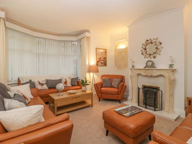 A living room with leather sofas a coffee table a fireplace and a floor lamp at Hillcrest in Scarborough