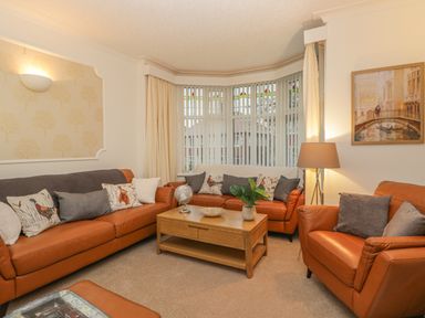 A living room with brown leather sofas a wooden coffee table and vertical window blinds at Hillcrest in Scarborough