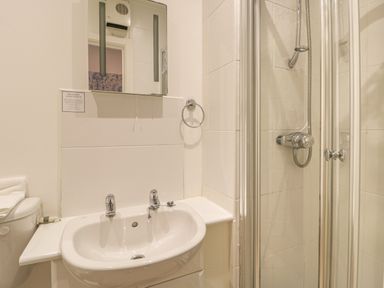 A bathroom with a sink and taps mirror and shower with glass door at Hillcrest in Scarborough
